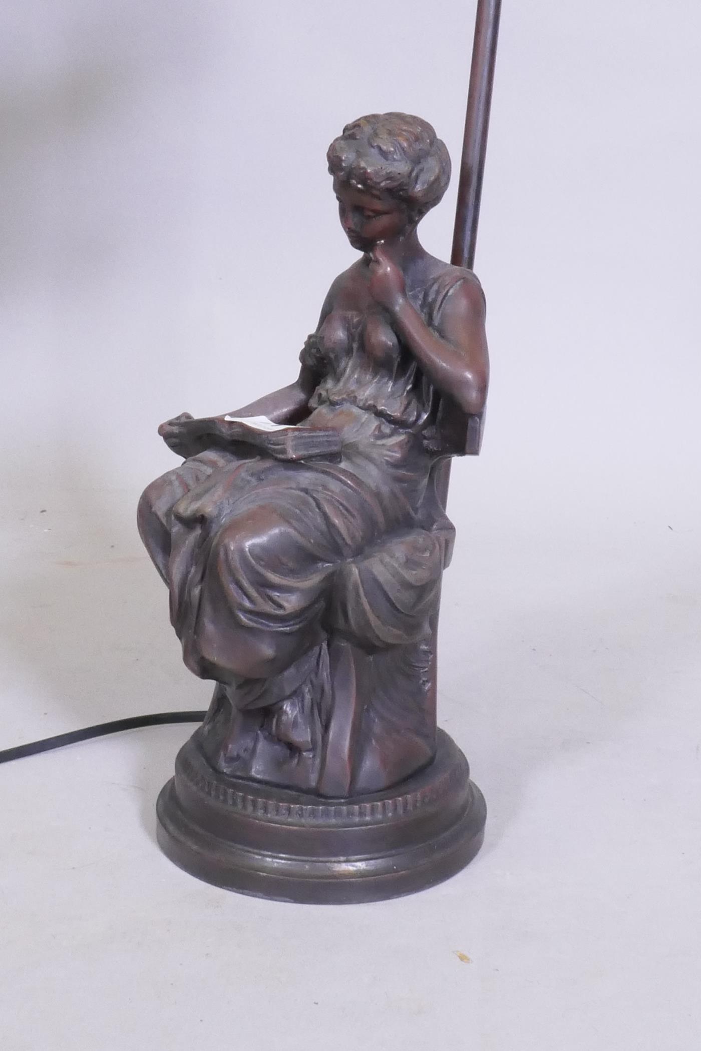 A bronzed composition table lamp in the form of a seated young woman reading a book, 57cm high - Image 2 of 2