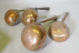 Four antique tinned copper Middle Eastern cooking vessels, one handle engraved with Arabic script,