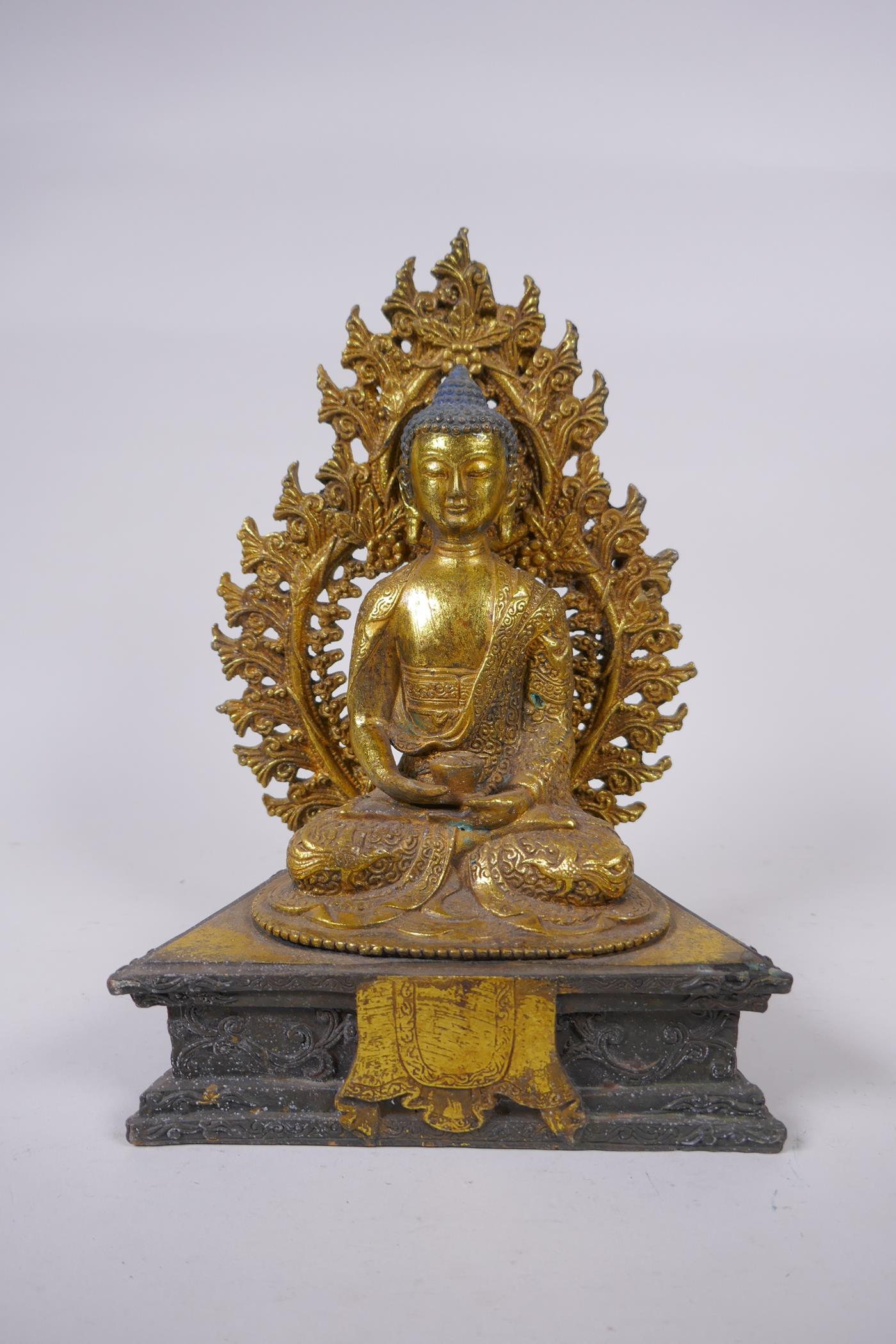 A Sino Tibetan gilt bronze figure of Buddha seated on a dias, Chinese 4 character mark verso