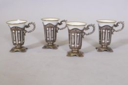 A set of four Limoges porcelain beakers with sterling silver holders, 150g