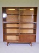 A mid century Beaver & Tapley Ltd multi width teak bookcase unit in two sections, with glass and