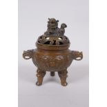 A Chinese bronze two handled censer and cover raised on tripod supports with raised dragon