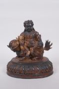A Sino Tibetan gilt bronze figure of an armoured deity seated on a temple lion, 22cm high