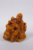 A Chinese soapstone style composition figure of Lo-han seated on a temple lion, 11cm high