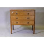 An Edwardian oak chest of three long drawers, raised on square supports, 84 x 43 x 83cm