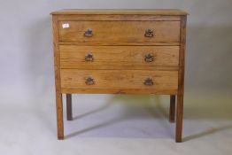 An Edwardian oak chest of three long drawers, raised on square supports, 84 x 43 x 83cm