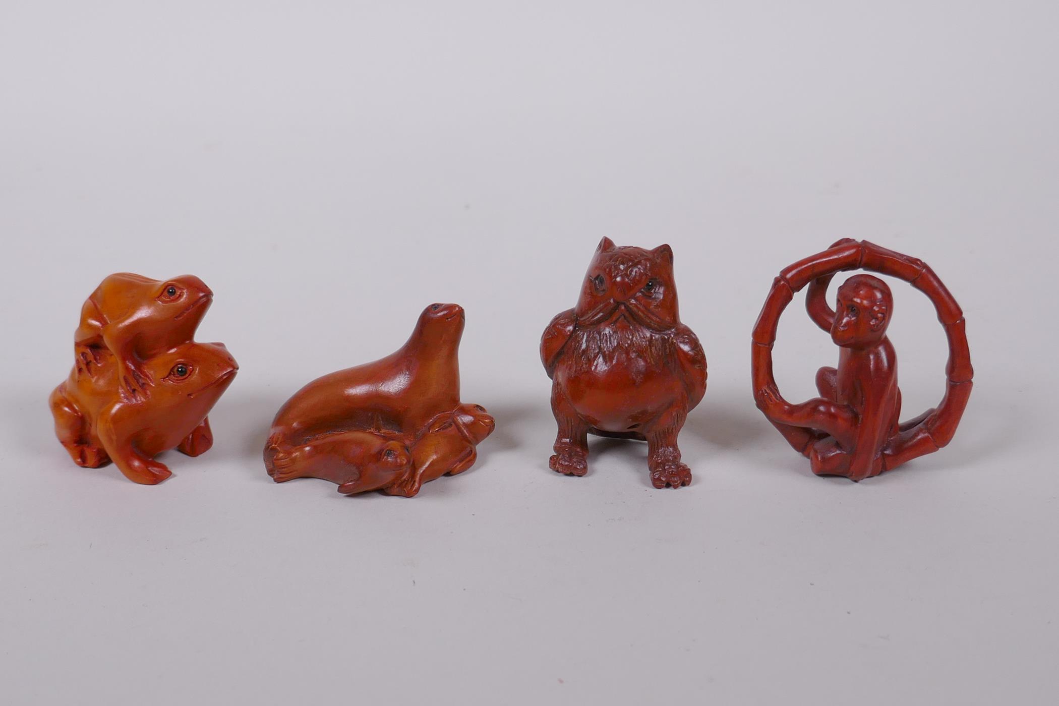 Four Japanese carved boxwood netsuke in the form of a monkey, owl, two frogs, and a seal with