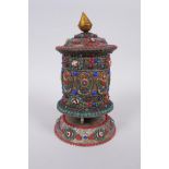 A Tibetan white metal prayer wheel with painted details, set with agate eye beads, turquoise etc,