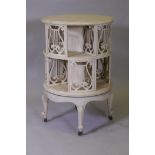 A Victorian revolving bookcase with pierced lyre shaped decoration, raised on cabriole supports with
