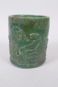 A Chinese green hardstone brush pot with carved tiger decoration, 12cm high x 10cm diameter