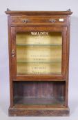 A C19th rosewood cabinet with single drawer and glass door, later sign-written in gilt with