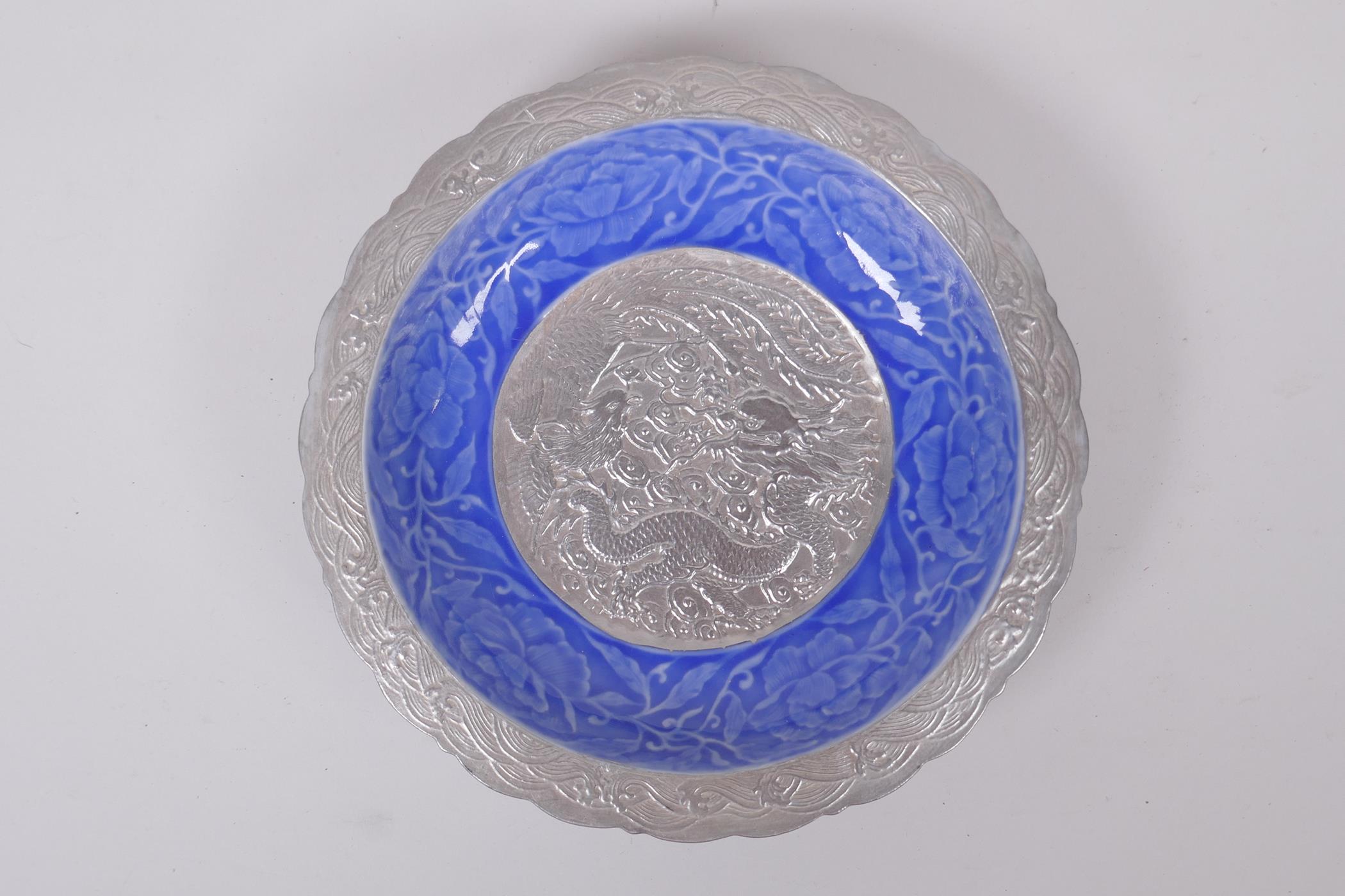 A Chinese blue and silver glazed porcelain dish with lobed rim, decorated with a dragon, phoenix and