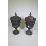 A pair of carved wood urns and covers with classical style decoration of putti riding a goat, 87cm