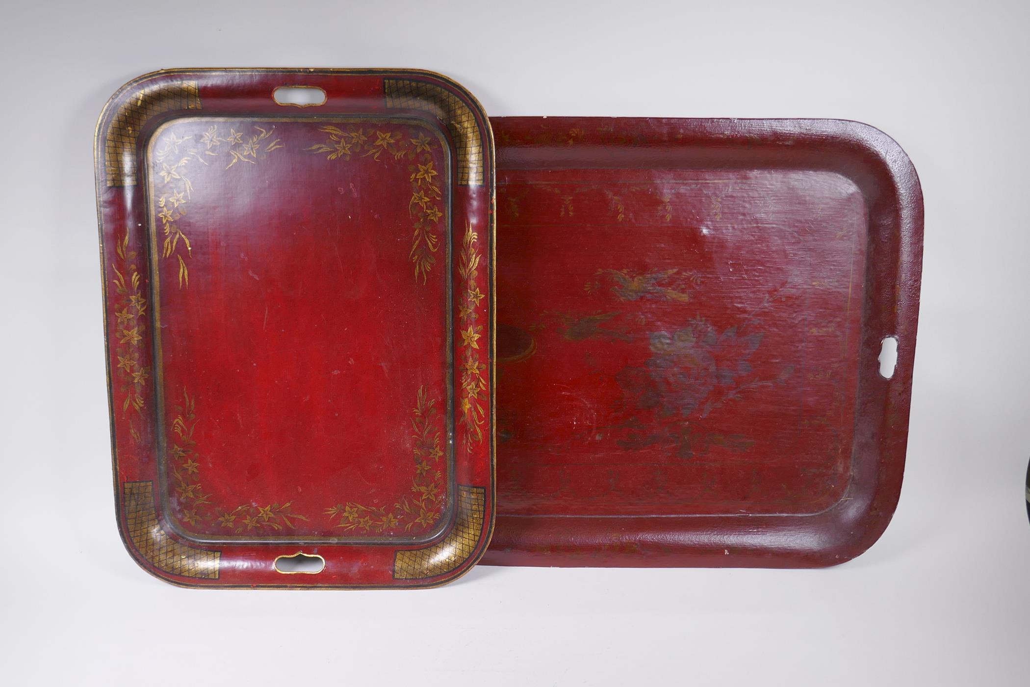 A red ground Toleware tray with gilt decoration of birds and a fountain, and another smaller,