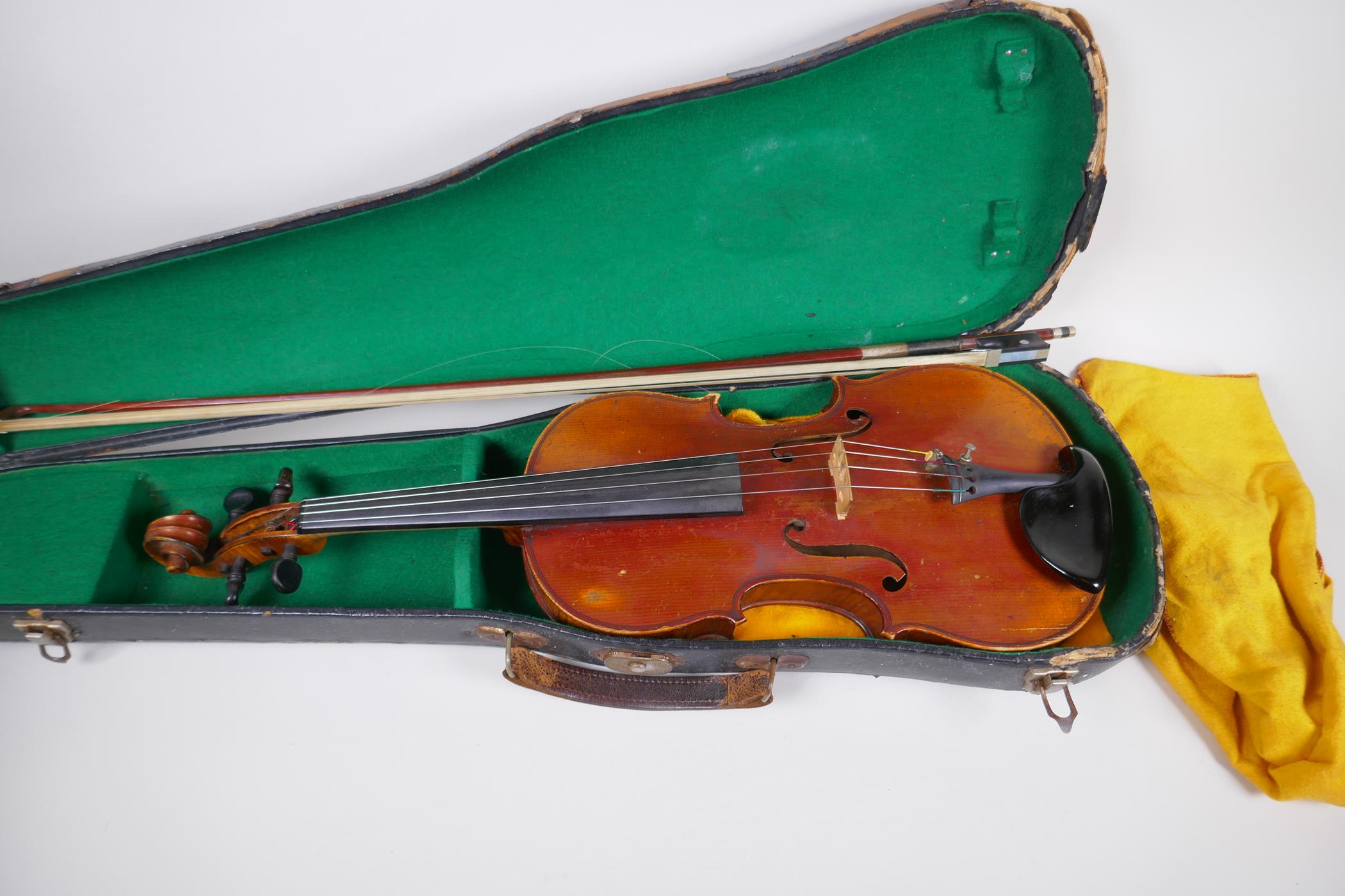 A vintage violin with two piece back and ebony pegs, with a bow and hard carry case, 60cm long