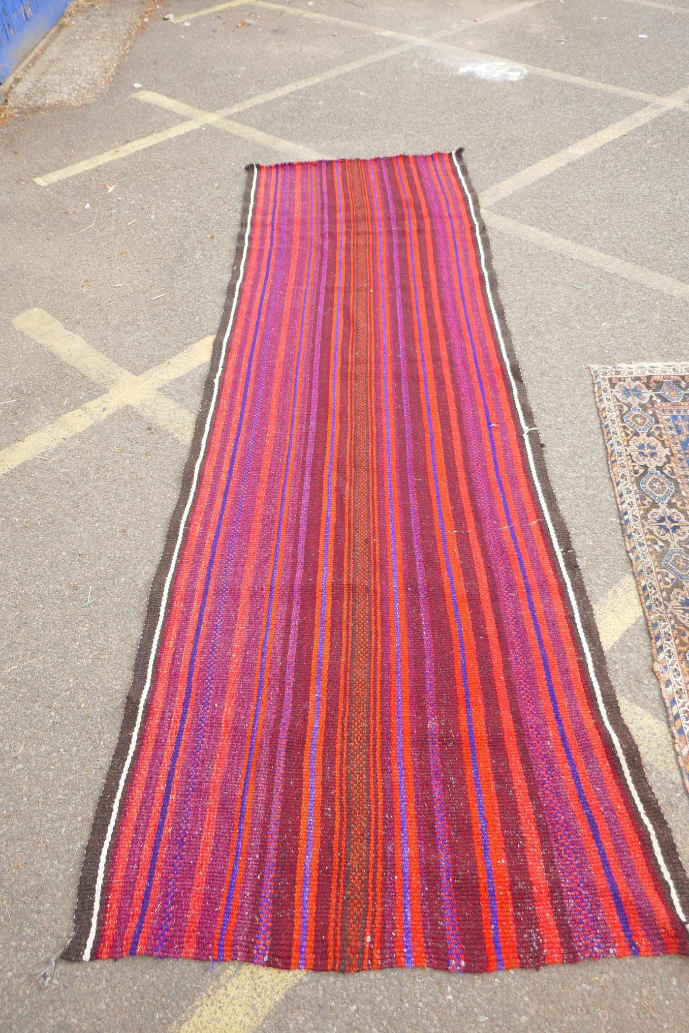 A red and blue ground flat weave runner, and a Persian red ground wool rug with a cream geometric