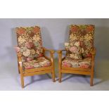 A pair of mid century beechwood reclining open arm chairs