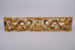 A Chinese carved and giltwood panel decorated with two dragons and a pearl, 60 x 12cm, 5cm high