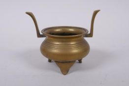 A Chinese bronze two handled censer on tripod supports, 9cm high