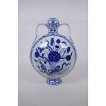 A blue and white porcelain moon flask with garlic head shaped neck and two handles, decorated with a