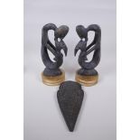 A pair of African carved hardwood figure groups, and a Tibetan carved wood plaque, largest 28cm high