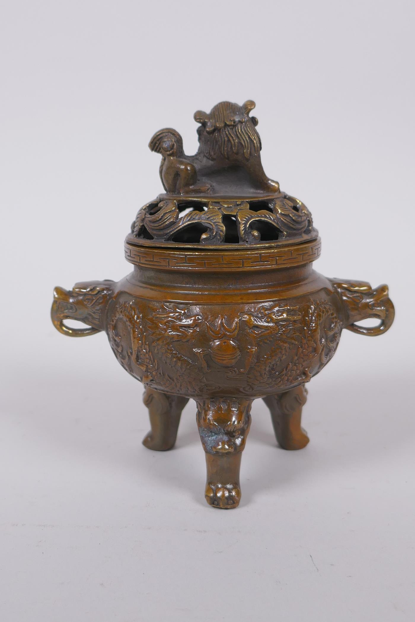 A Chinese bronze two handled censer and cover raised on tripod supports with raised dragon - Image 4 of 5