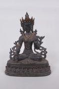 A Tibetan bronze figure of a seated female deity, with gilt highlights and set with semi precious