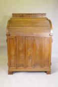 A late C19th/early C20th walnut tobacconist's shop cabinet, the roll top opening to reveal drawers