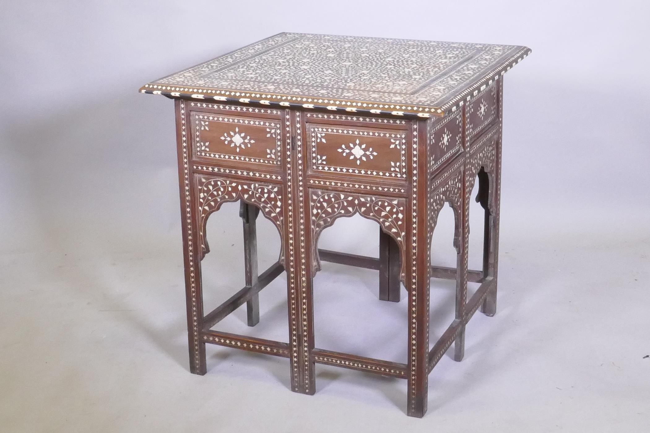A C19th Moorish table with inlaid decoration and folding base, 61 x 61 x 63cm