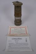 A Cambrian Lampworks brass miner's flame safety lamp by E. Thomas & Williams Ltd, with