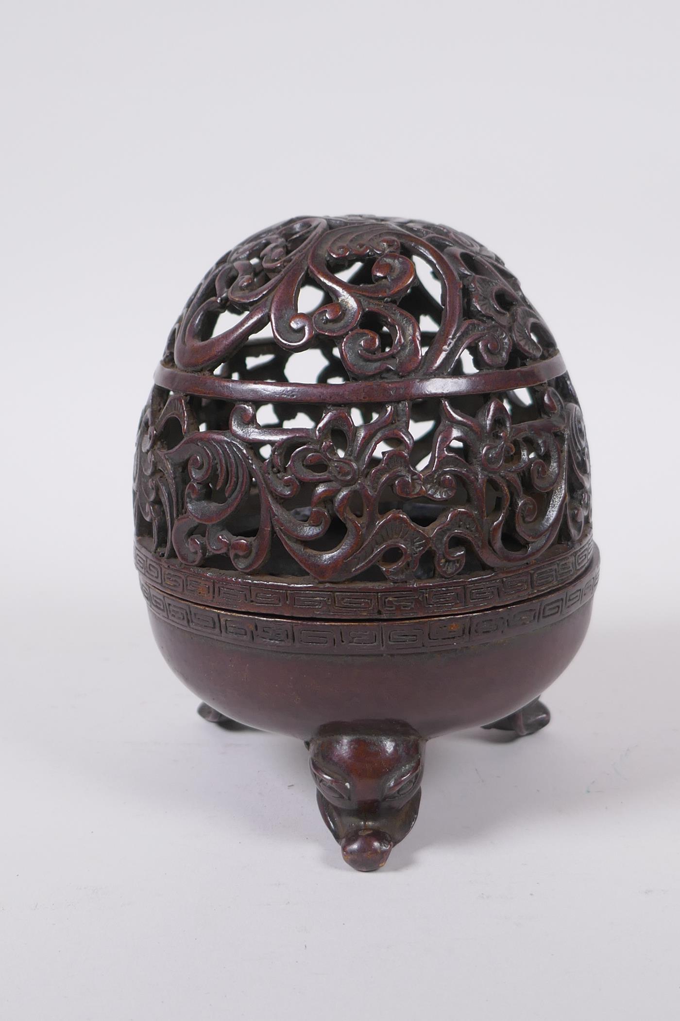 A Chinese bronze censer and pierced cover with tripod supports and scrolling floral decoration, 4 - Image 2 of 5