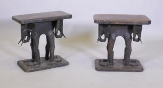 A pair of antique African carved wood stools, raised on elephant supports, 46 x 27 x 44cm