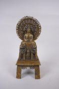 A Sino Tibetan bronze Buddha seated on Fo-dogs, standing on a disc, character inscription verso,