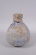 An Islamic blue glazed earthenware pourer with bearded face decoration