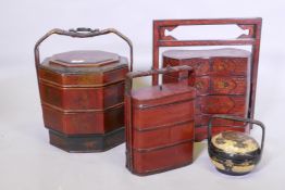 A Chinese three section food container with lacquered decoration, plaited cane handle with metal