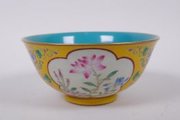 A polychrome porcelain rice bowl with famille rose enamel decorative panels within a yellow
