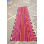 A red and blue ground flat weave runner, and a Persian red ground wool rug with a cream geometric