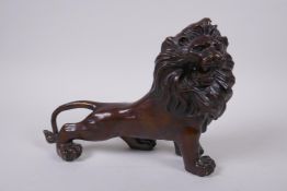 A filled bronzed metal figure of a lion, 26cm long
