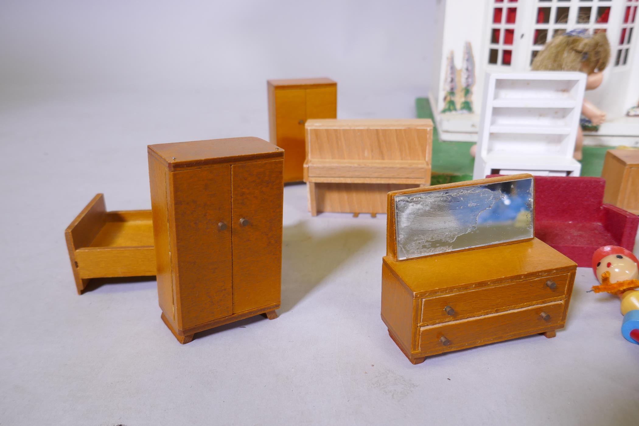 A mid century doll's house with sliding metal front, illuminated and with furnishings, mounted on - Image 3 of 7