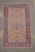 An antique Turkish pink ground wool rug with tree of life design, 82 x 130cm