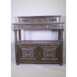 A Victorian oak buffet, the upper tier with two drawers, the lower with cupboards, with carved