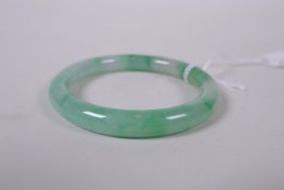 A Chinese mottled nephrite bangle, 5.5cm interior diameter