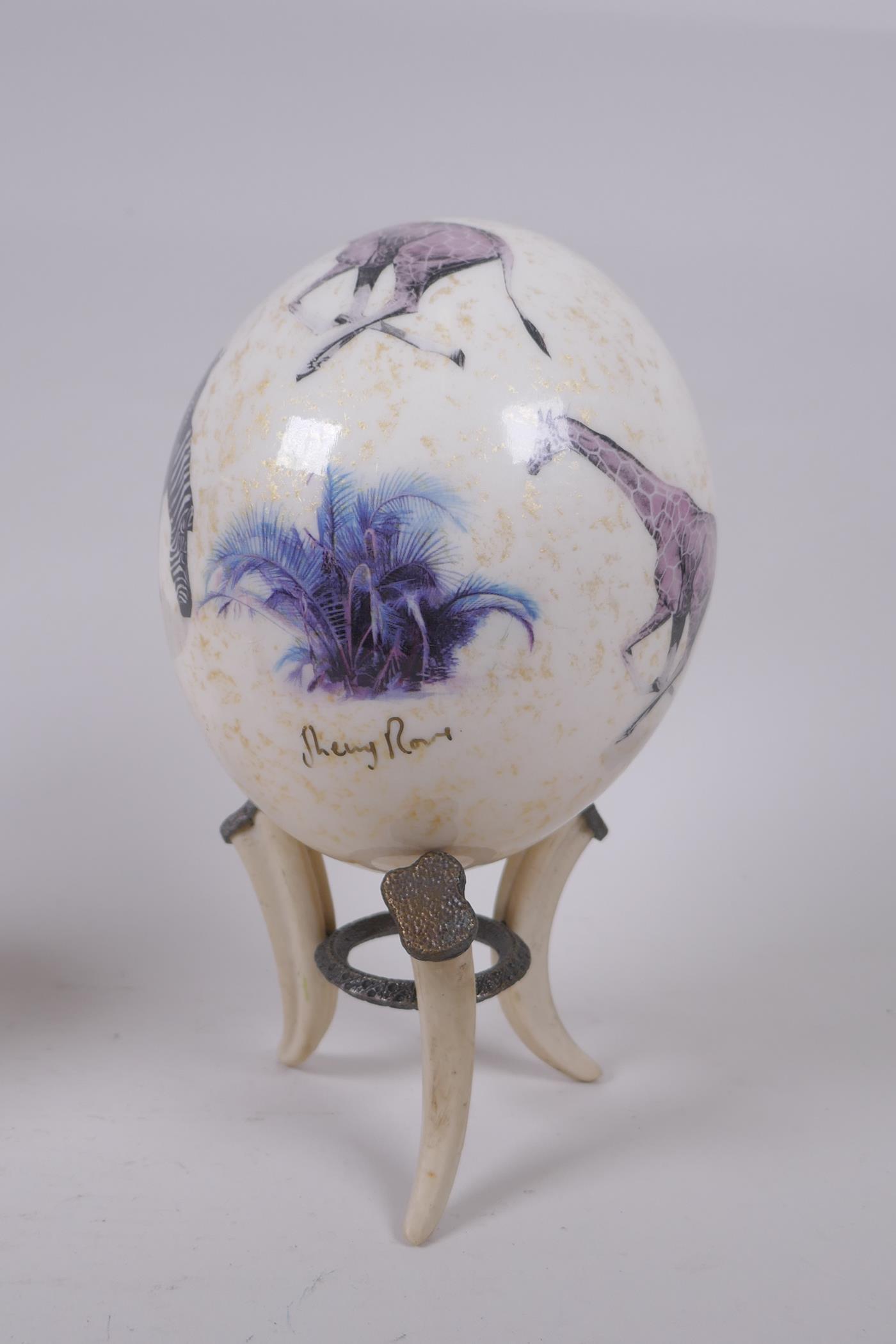 A decorative gilt and collage ostrich egg on stand by Sherry Rowe, and another undecorated ostrich - Image 2 of 7
