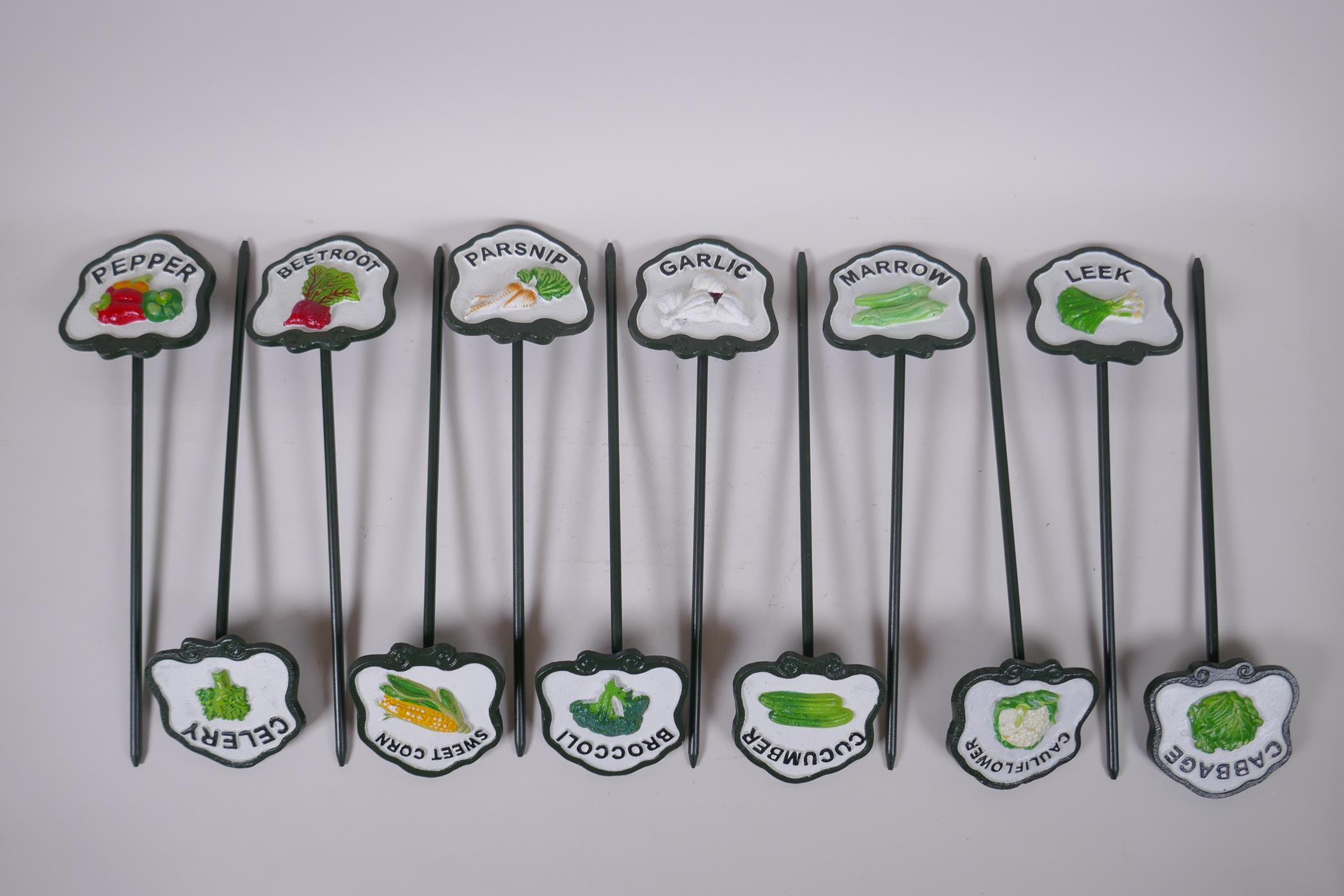 A set of 12 painted cast metal vegetable markers, 32cm long