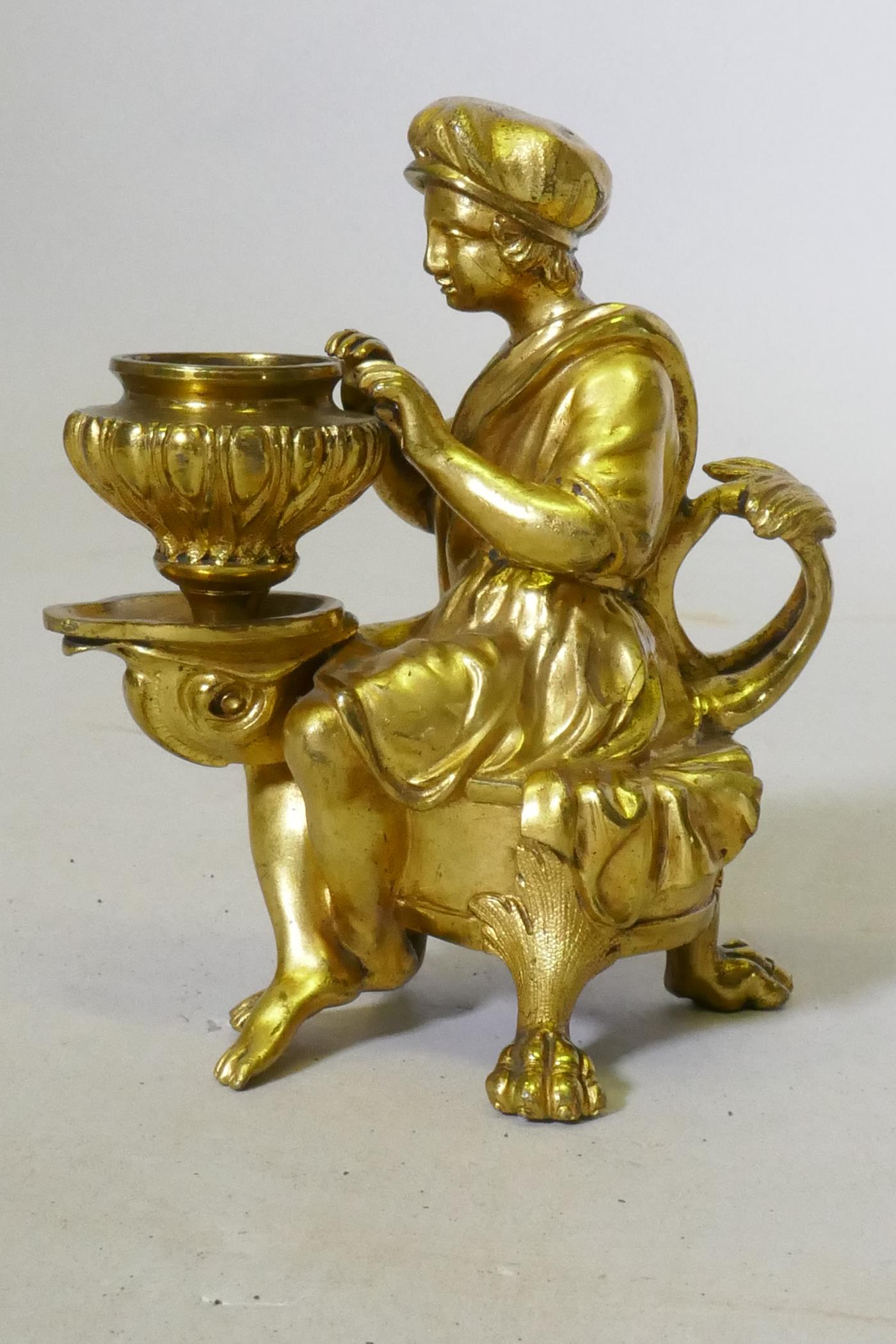 A fine Grand Tour ormolu bronze chamberstick in the form of a page seated upon a dolphin, C18th/