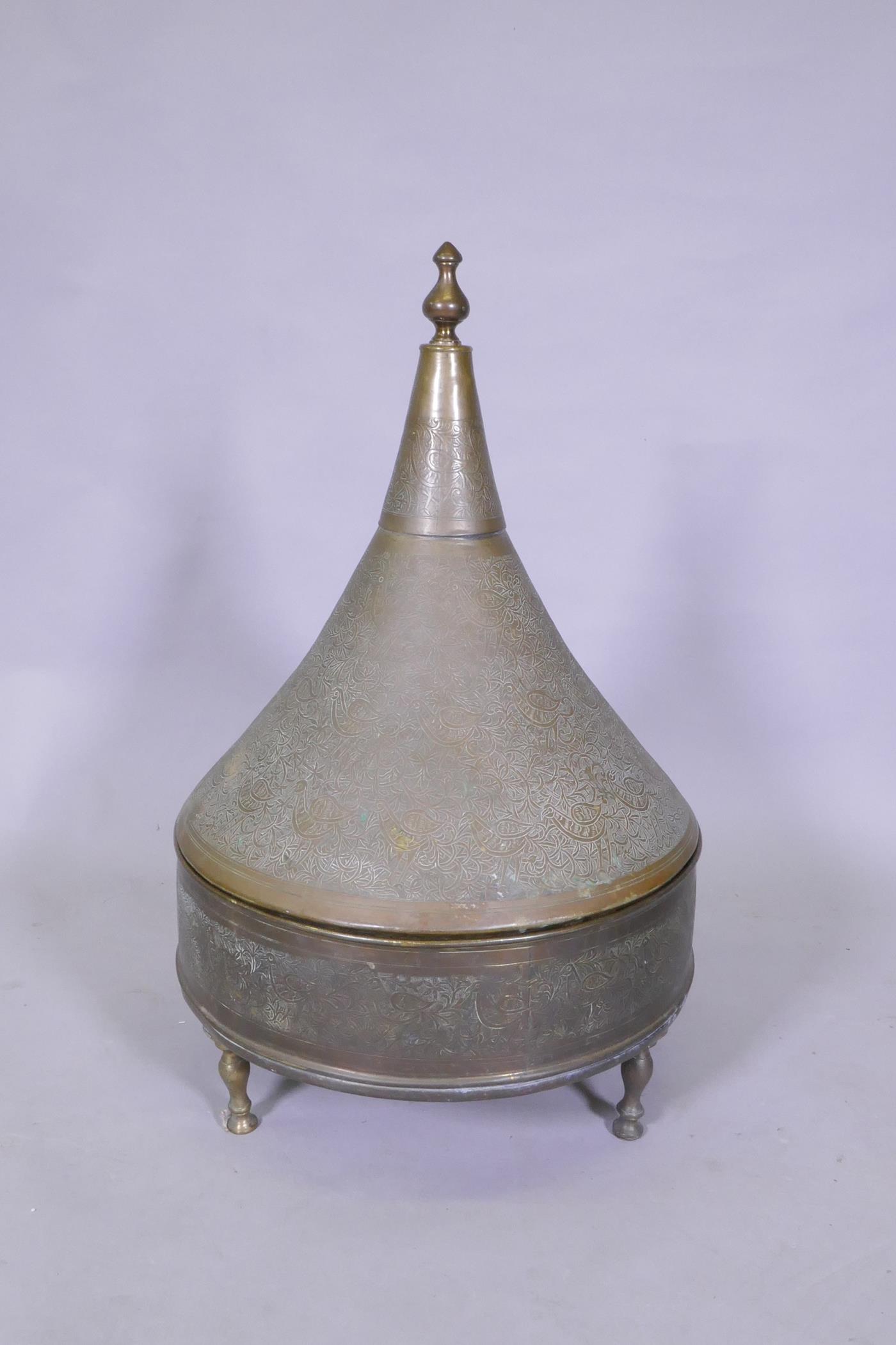 An antique Indo Persian brass brasserie and conical cover, raised on tripod supports, with chased