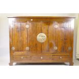 A Chinese hardwood cabinet with brass mounts and folding doors, raised on shaped supports, 186 x