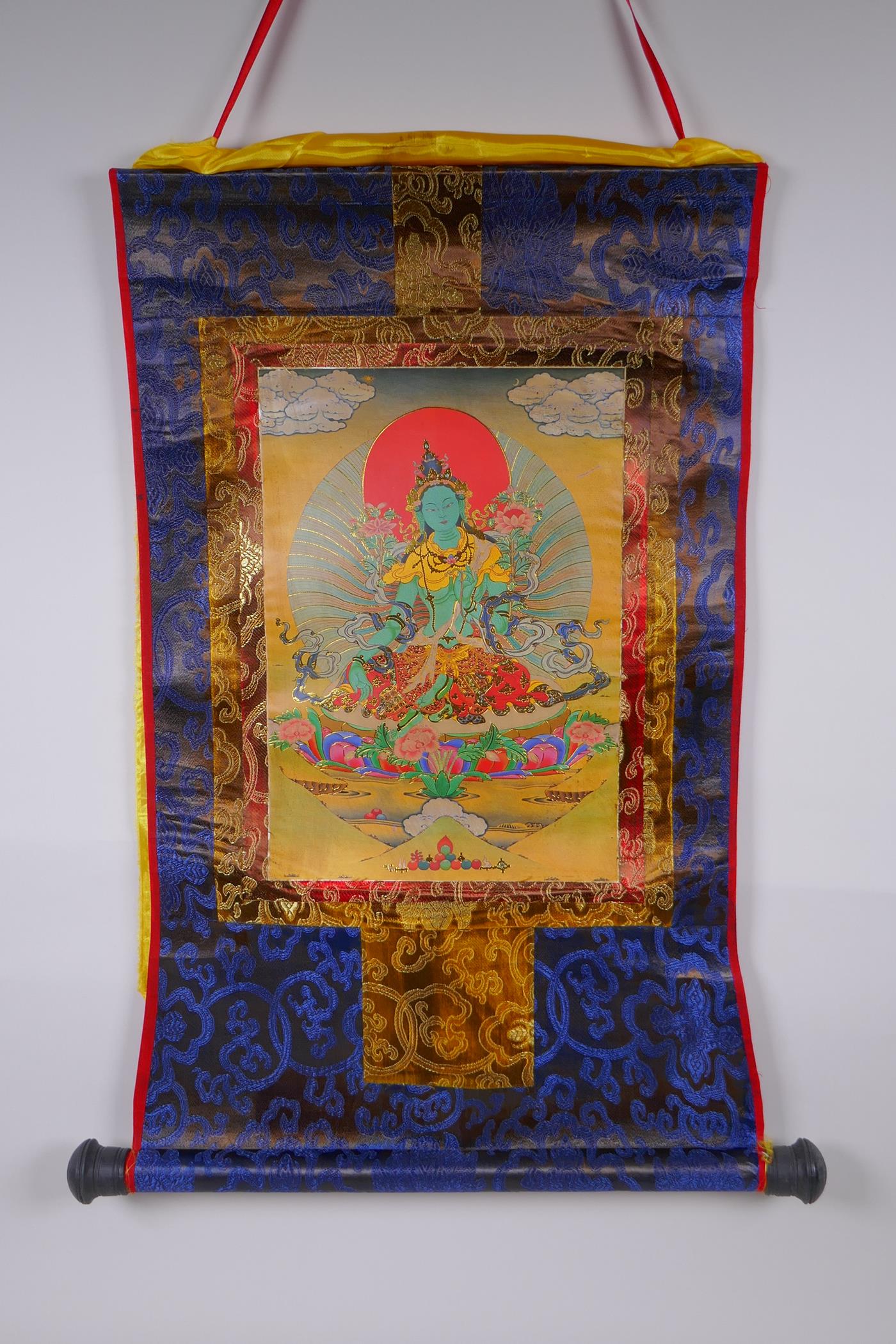 A Tibetan printed Thangka with gilt details, on a silk scroll mount, 49 x 62cm