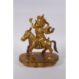 A Sino Tibetan gilt bronze figure of a deity riding a donkey, 22cm high