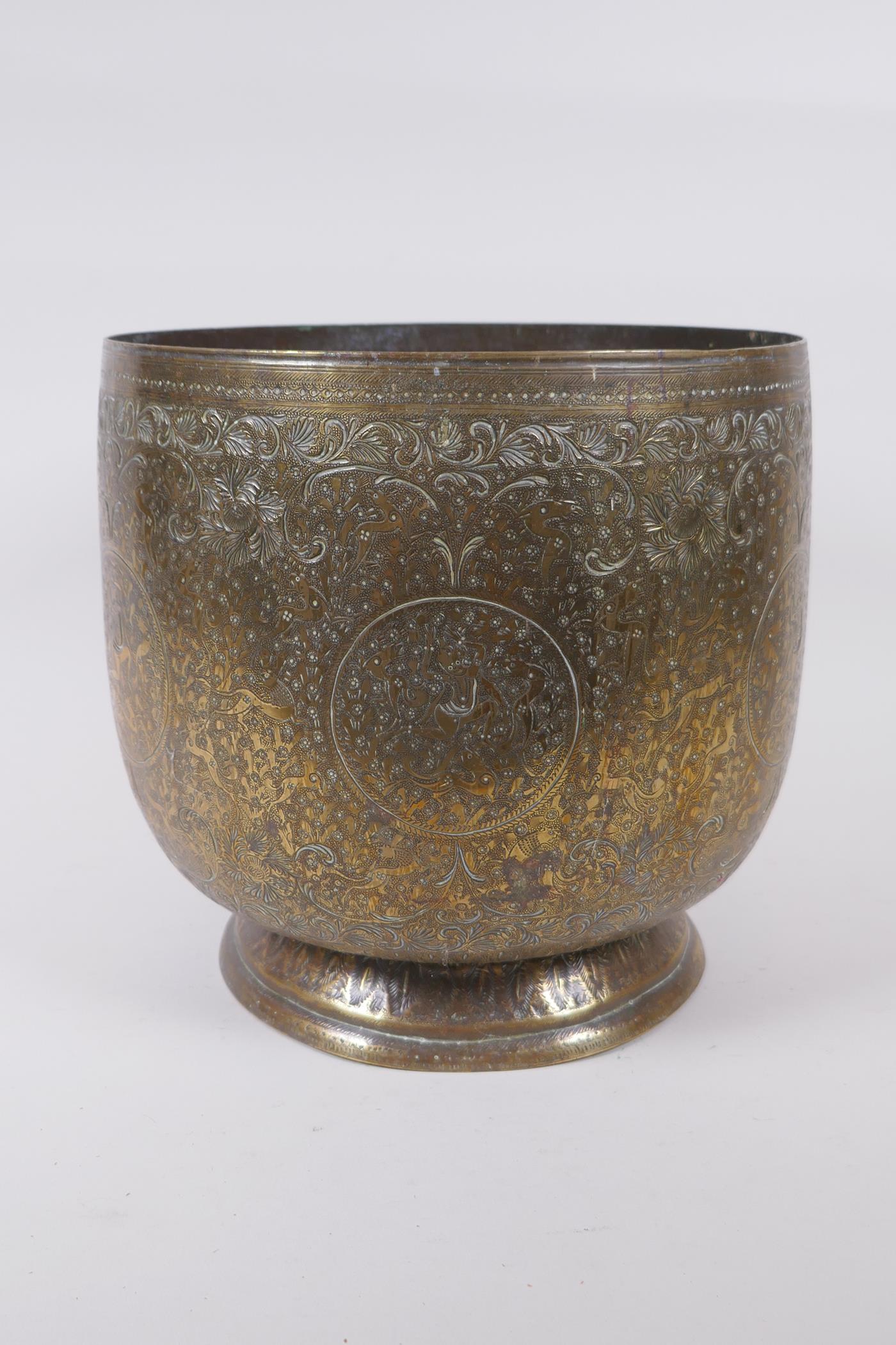 An antique Indo Persian brass planter with chased and hammered decoration of dancing figures and